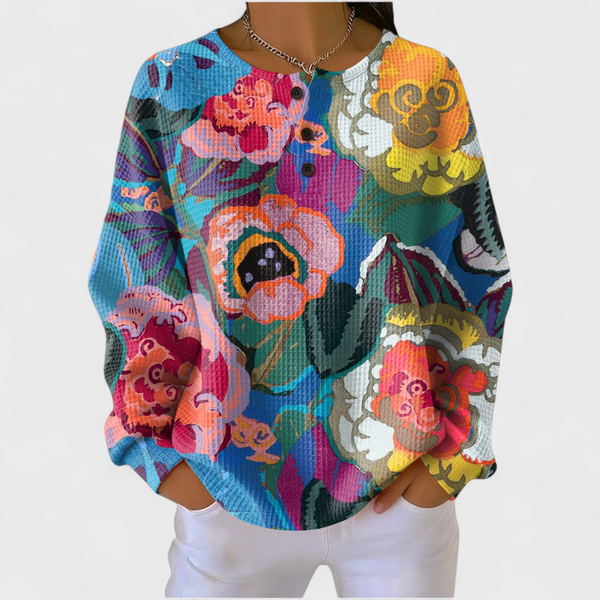 Women's blue waffle jumper with oversized colourful floral print and button neckline